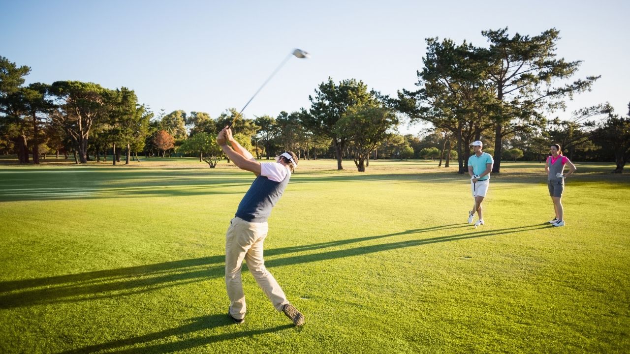 Golfer teeing off on a sunny Ontario golf course fairway